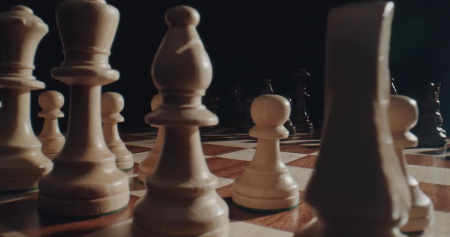 A chess board has all of the pieces lined up in their starting positions before the game commences