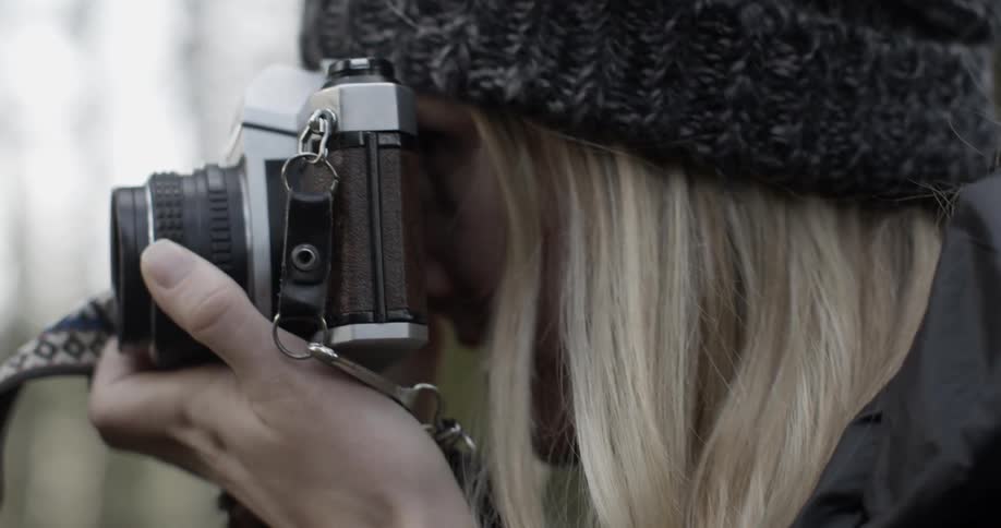 A woman takes a photograph with a camera
