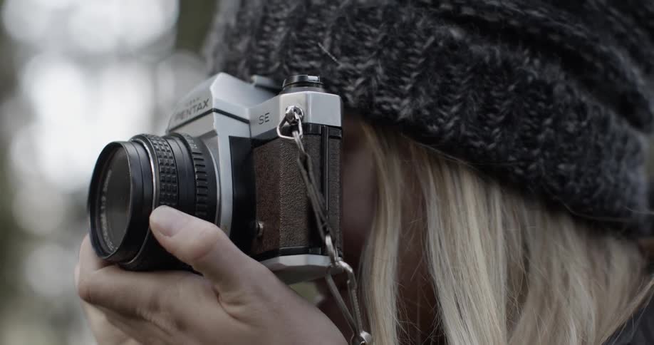 Smiling blonde shooting pictures with her camera