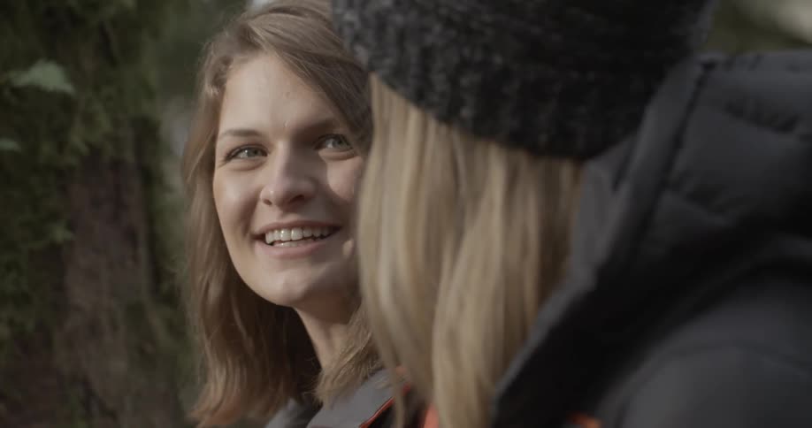 A woman looks at another woman while she talks and laughs