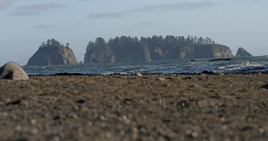 Water is crashing against the shore on a cloudy day