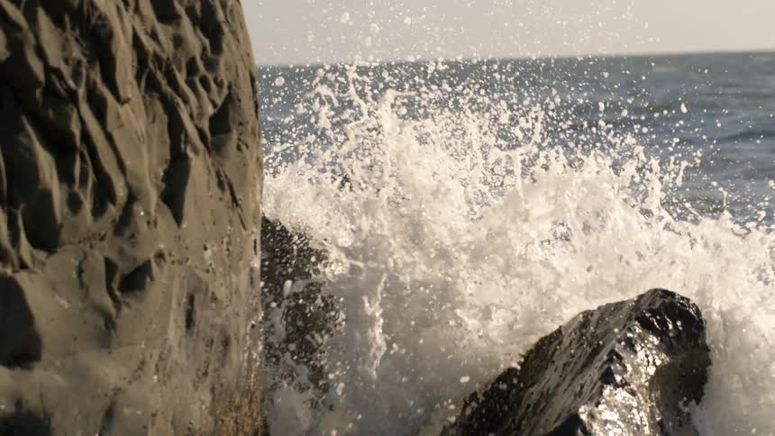 Ocean waves crash into a rock