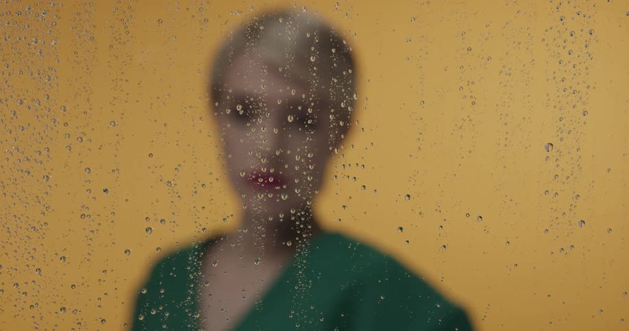 A woman standing in front of a glass piece with water on it