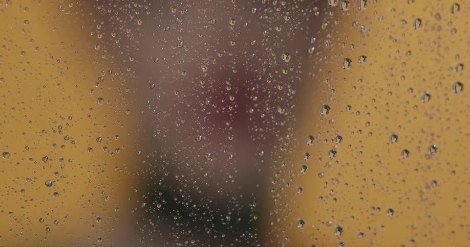 A person walks up to the wet glass