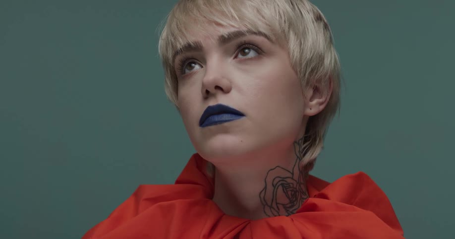 Young blonde short haired woman with blue lips looks at the camera modelling