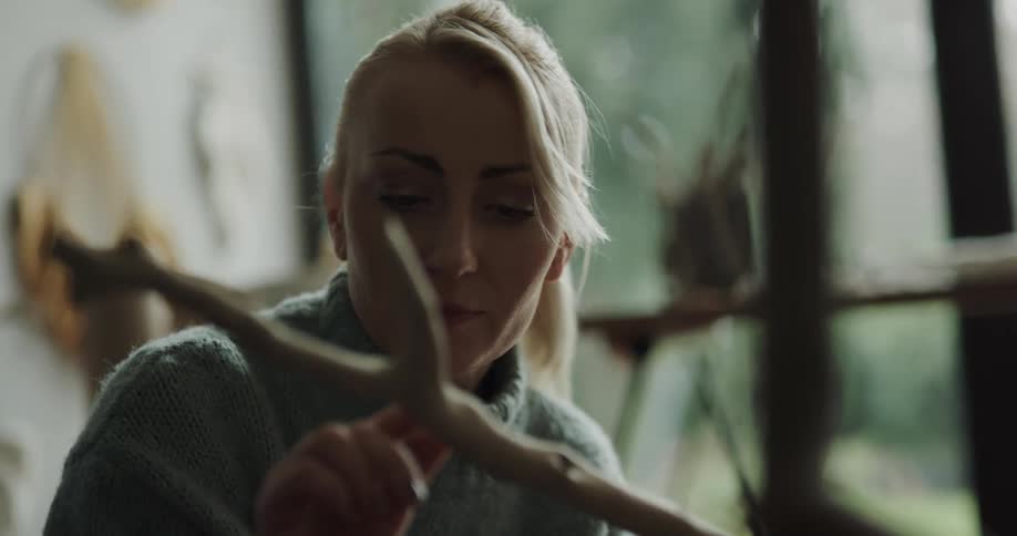 A woman looking at a stick in an art studio