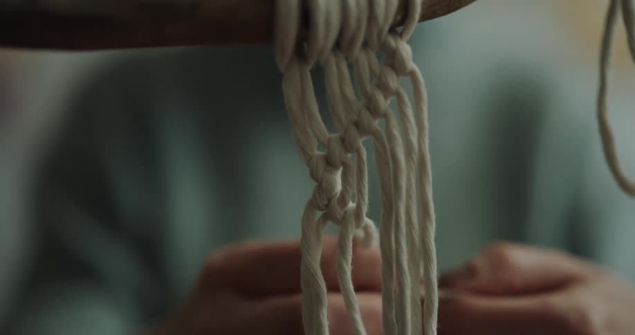 A person tying string on a bar