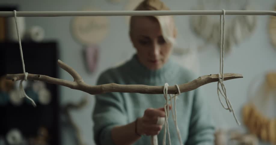 A woman is doing crafts indoors during the day