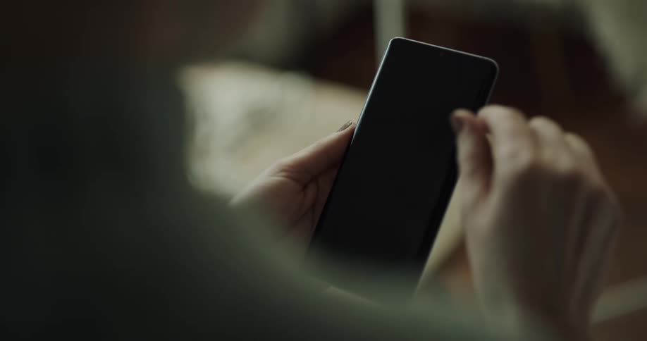 A person is using a smart phone while sitting indoors