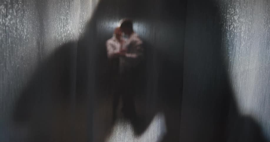 Two people dancing behind a see through curtain