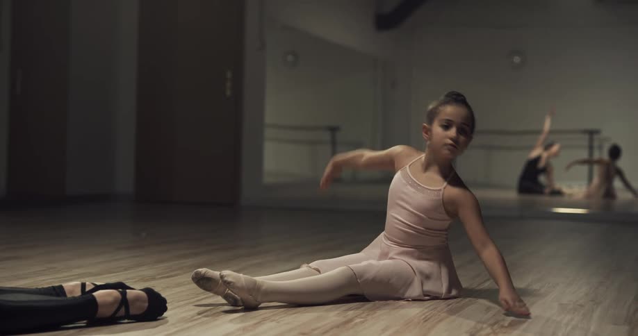 A girl following dancing instructions from a woman