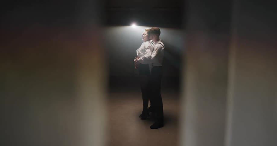 A man and woman are dancing in a room together