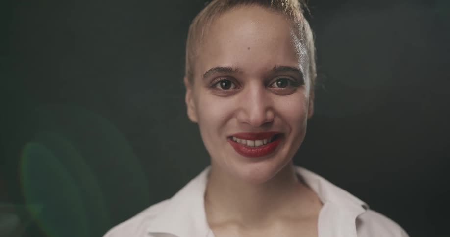 A woman with brown eyes smiles while looking forward