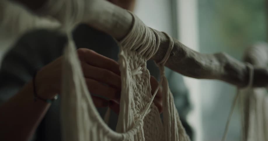 A woman is doing crafts indoors during the day