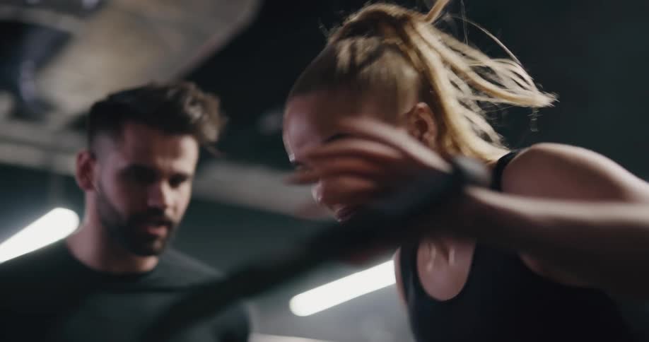 A coach motivates a teenage girl as she exercises