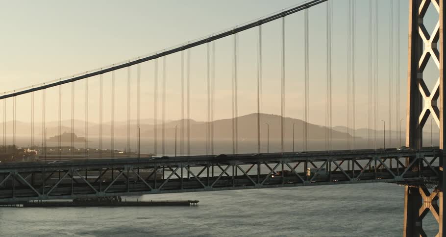 Aerial view of vehicles driving over a bridge and water