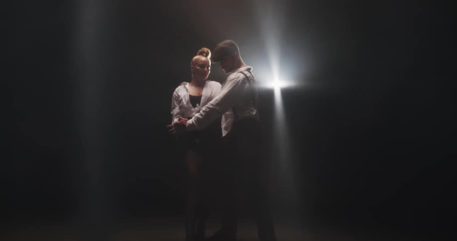 A man and woman dancing under a spotlight