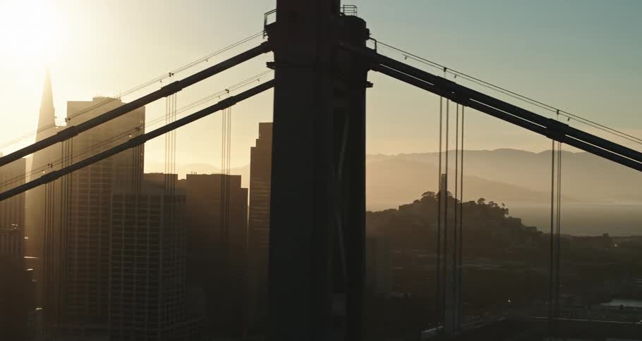 Aerial view of the sun setting over the san francisco city skyline near the bridge