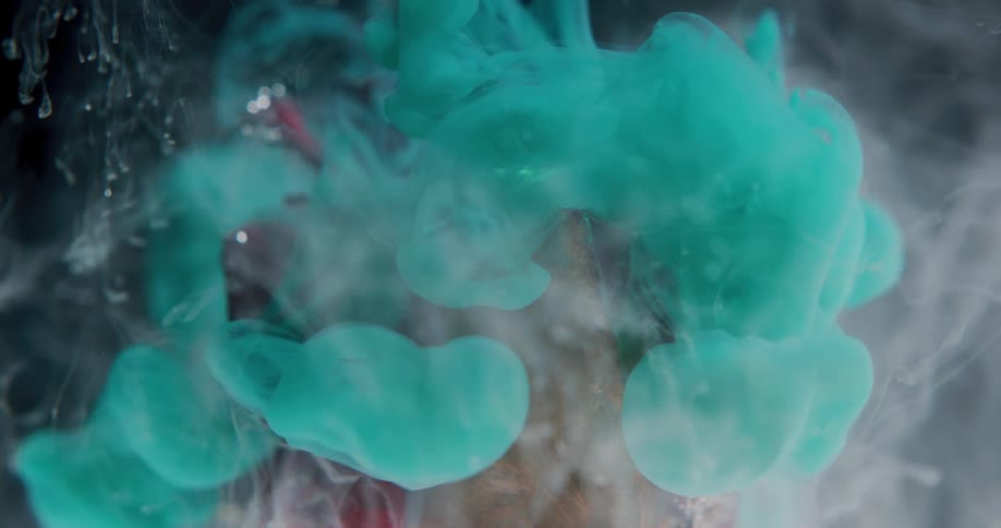 Bright green liquid ink flowing over a dry rose suspended in liquid