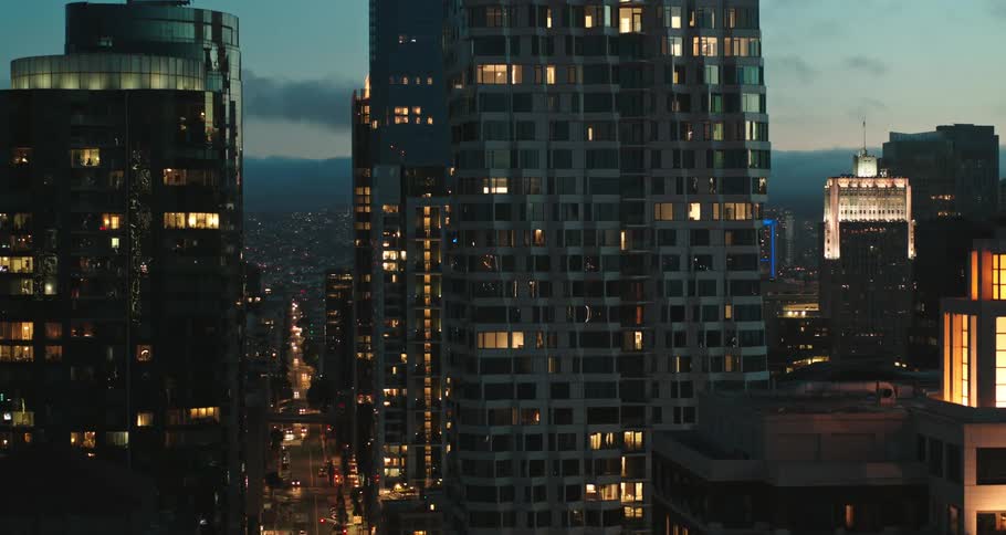 Light shimmers and reflects on city buildings at night