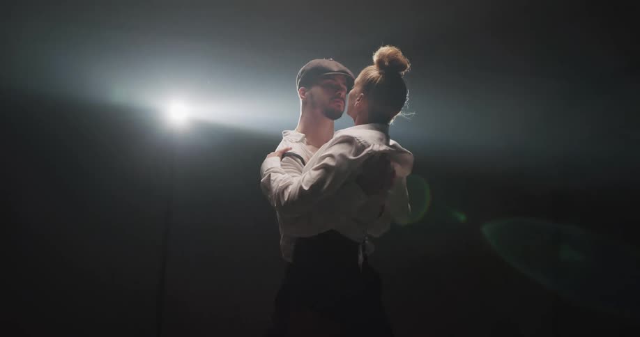 A man and woman dance under the spotlight