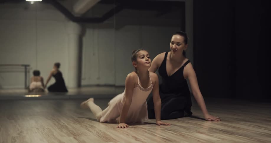 Ballet dancers stretch on the floor