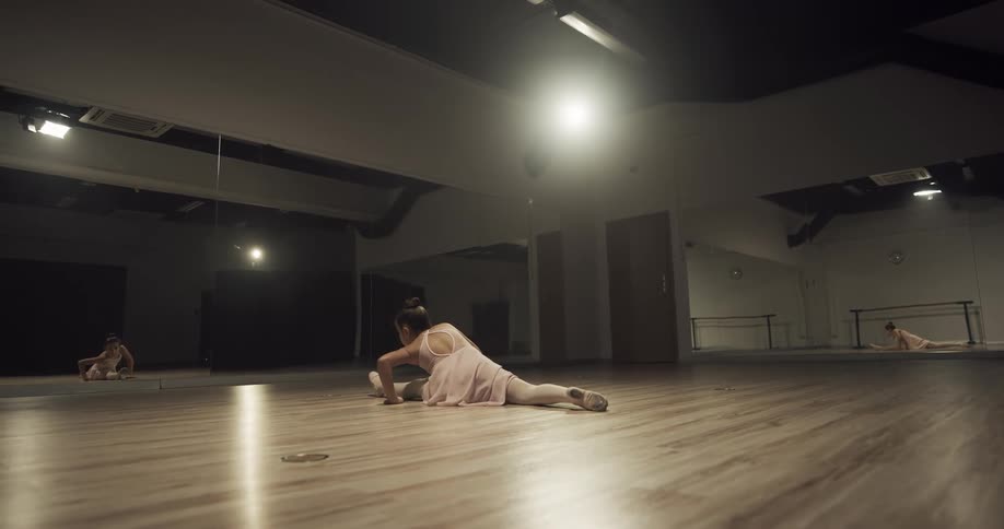 A girl is doing ballet in an empty room