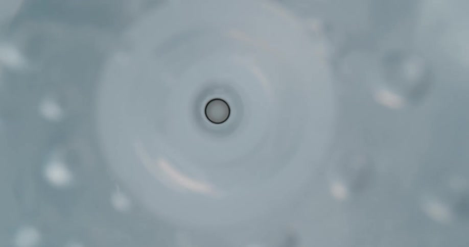 Footage of the interior of a syringe while liquid pours out of the needle