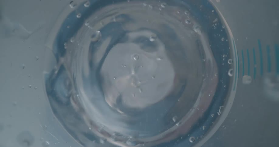 The inside of a bottle as water rushes in through a hole then bubbles