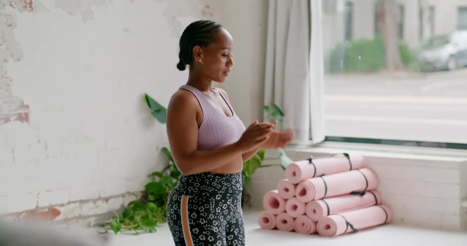Young fit woman wearing sports outfit teaching yoga on a online class through a laptop