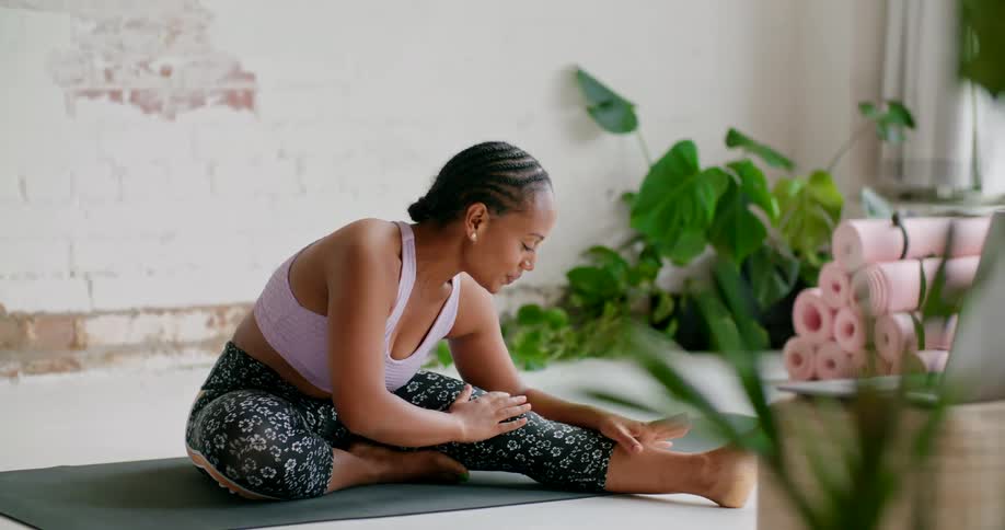 A woman stretches on a mat during exercise