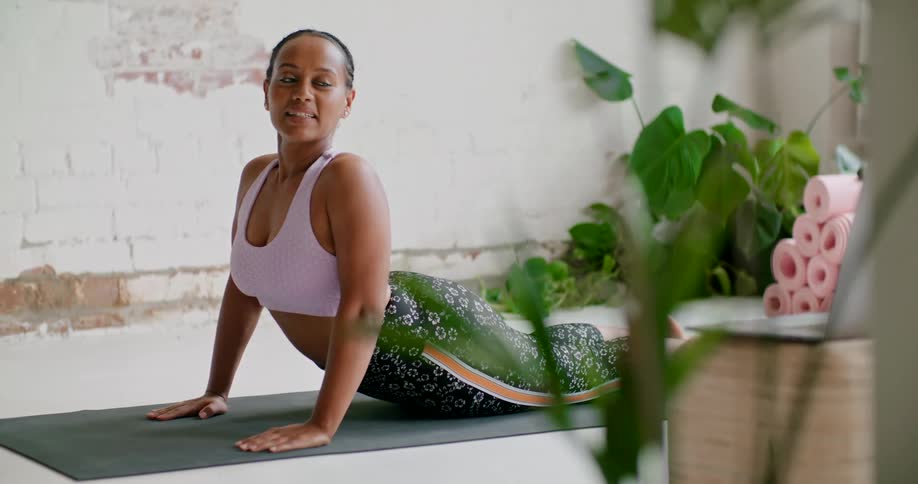 A woman stabilizes her upper body as she is prone on a yoga mat