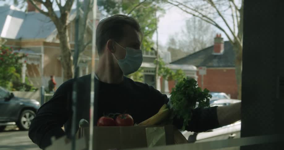 A man bringing groceries to a door