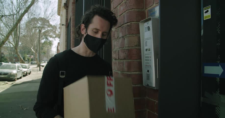 A man is delivering a package to a building
