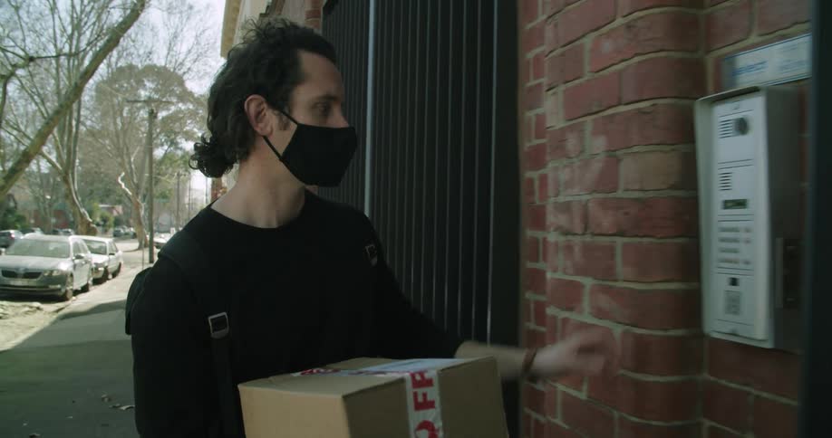 A man is delivering a package to the building