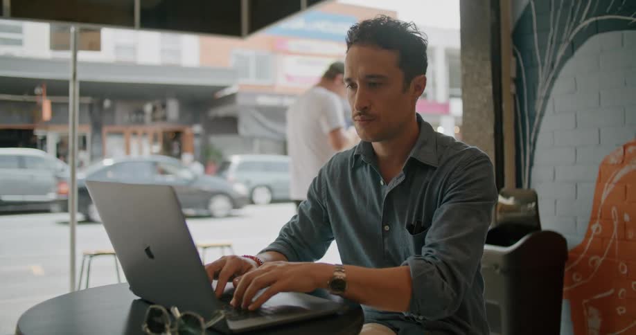 A man sitting outside with a laptop