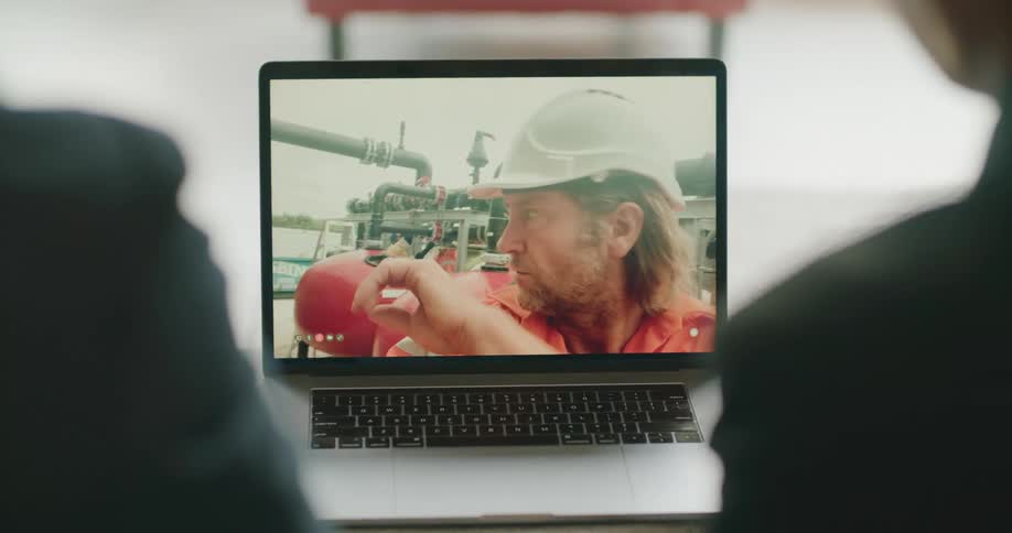 Two people talking to another man on a video call