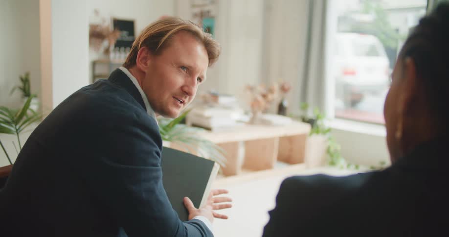 A man and woman sit in an office and talk
