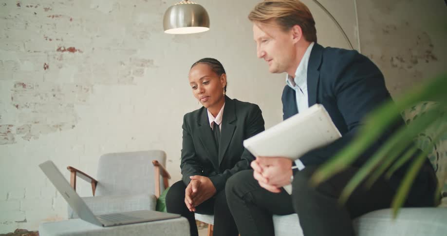 A man and woman at work talking on a laptop