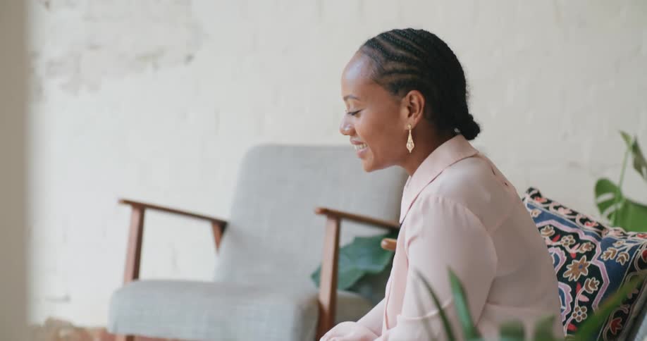 A woman is talking into a laptop while sitting indoors