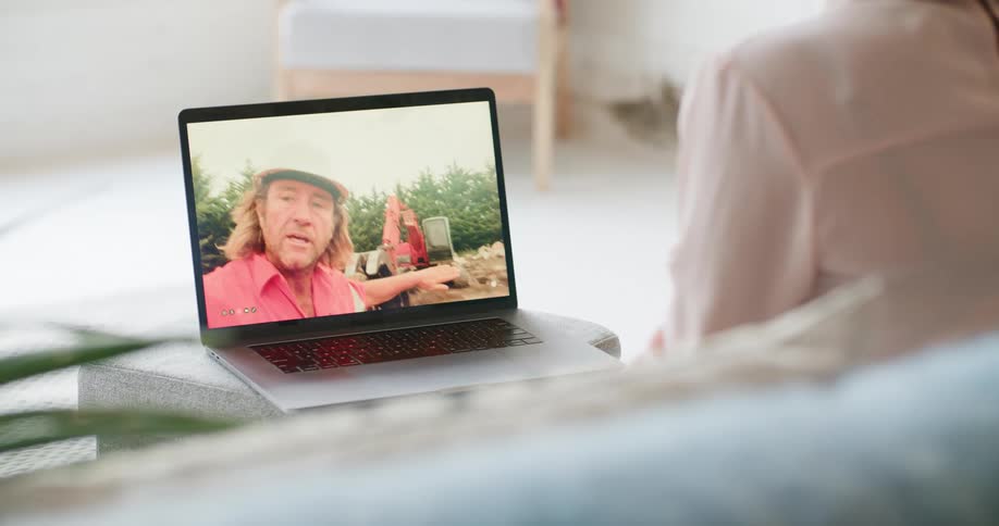 A woman chatting with a man in a hard hat on a video call