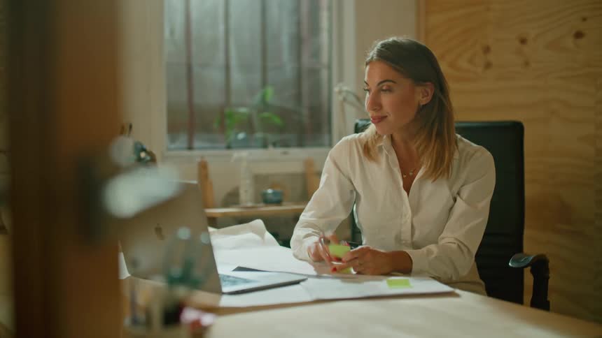 A woman is talking on video conference in her office