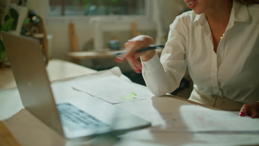 A woman in an office talks with someone on a laptop