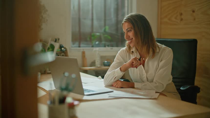 A woman is talking on video conference in her office