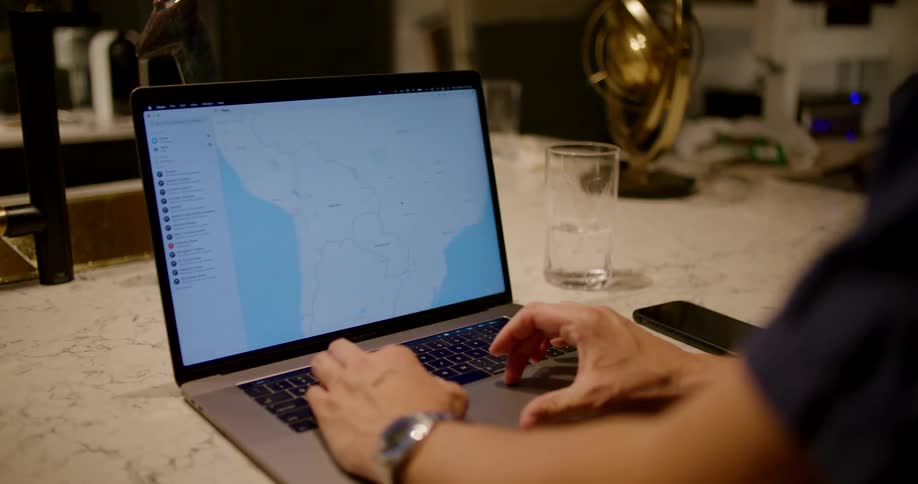 A man zooming in on a map of south america on a laptop