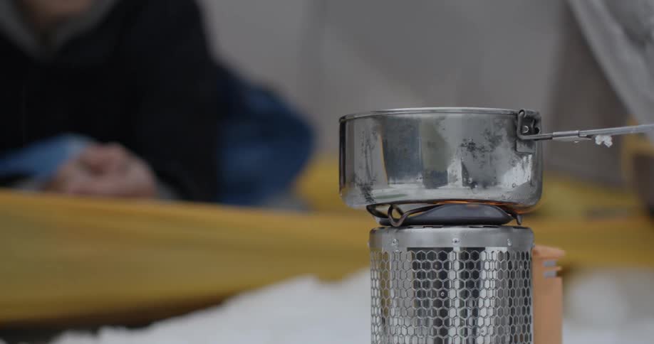 A pot on a camp stove lets off steam