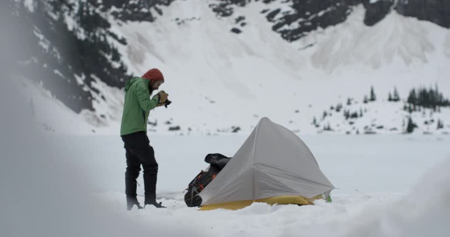 Person taking pictures of their campsite in the snowy wilderness