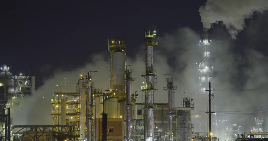 Clouds of steam and vapor rising from a power plant at night