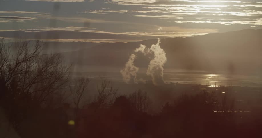 The factory at the bottom of the hill is giving off smoke