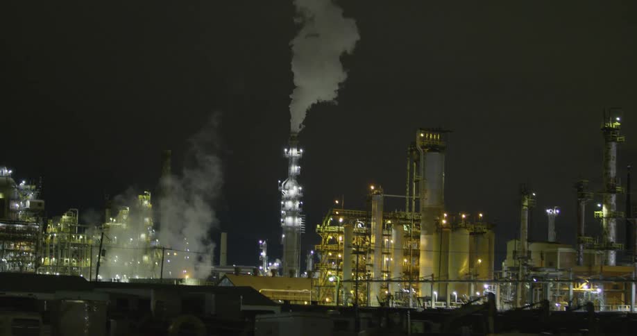 Industrial area with lights smoke and chimneys with the sky in the background
